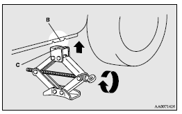 Mitsubishi Lancer: To change a tyre. 4. Insert the bar (D) into the wheel nut wrench (E). Then put the end of the